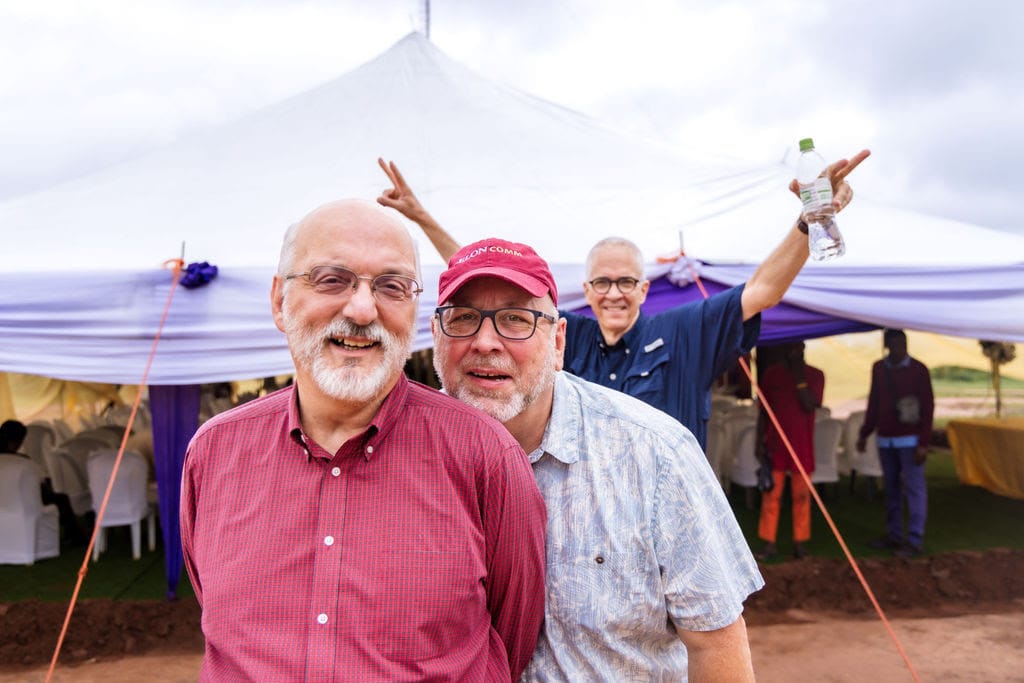 Three men post outside tent at Vision Africa's Media Institute 2024