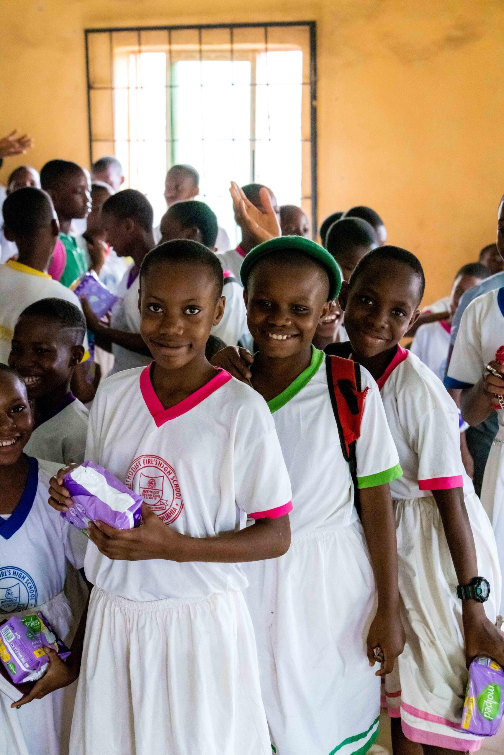 Children holding donated supplies for "My Stain, No Shame" Vision Africa program